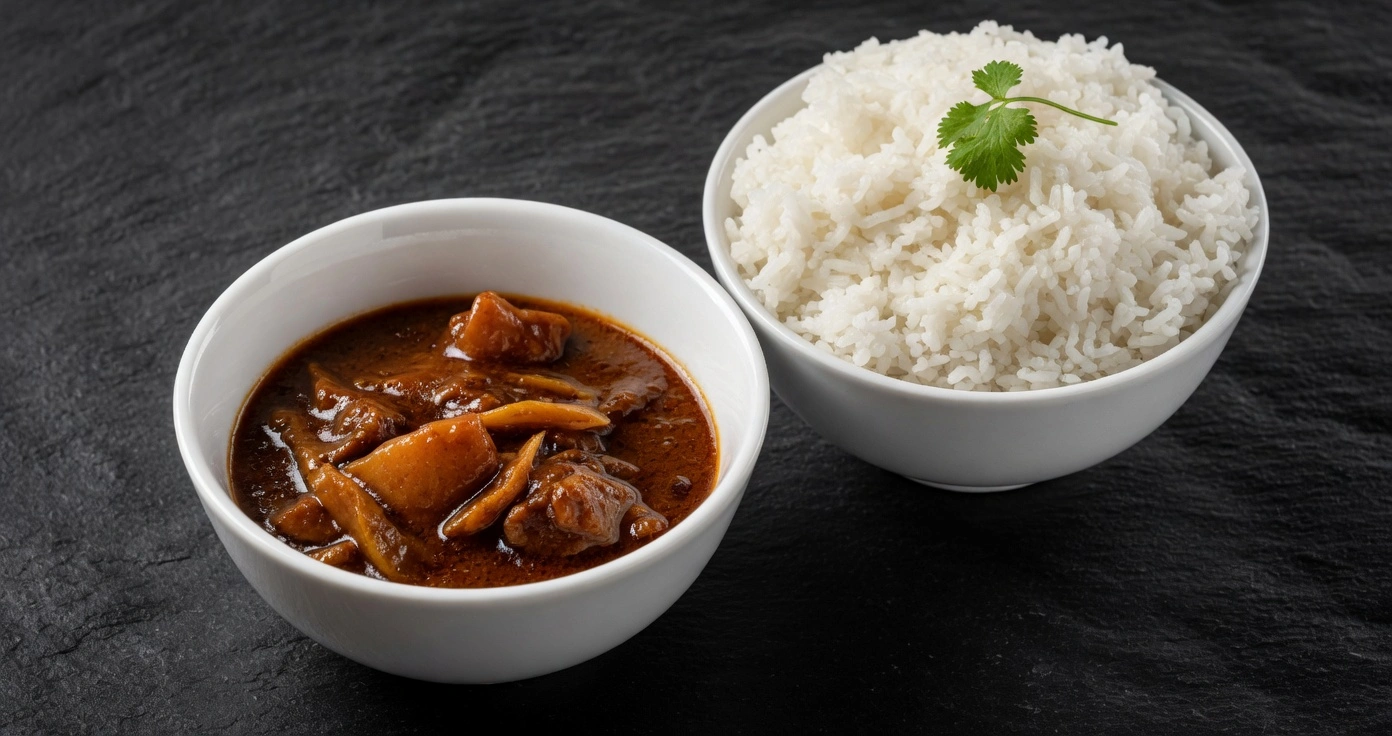 Bols de curry et riz parfumé dressés sur ardoise sombre